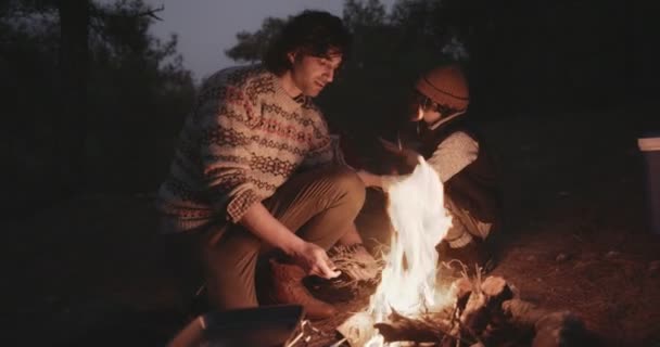 Ayah muda dan anak berkemah menyalakan api unggun di malam hari — Stok Video
