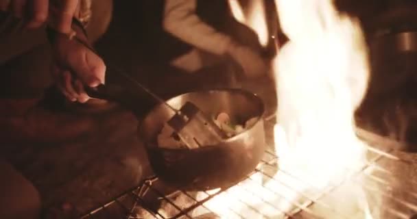 Homem cozinhar sobre fogueira no fim de semana de acampamento da família — Vídeo de Stock