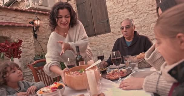 Abuela sirviendo almuerzo casero a la familia en pueblo mediterráneo — Vídeos de Stock