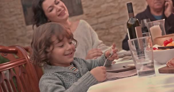 Jovem sentado com a família à mesa de jantar na aldeia — Vídeo de Stock