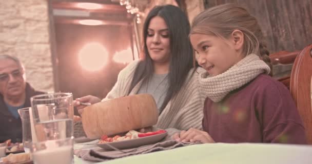 Moeder serveert lunch aan dochter tijdens een familiediner — Stockvideo