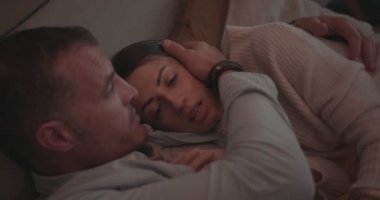 Romantik koca evde dinlenirken karısını kucaklıyor.