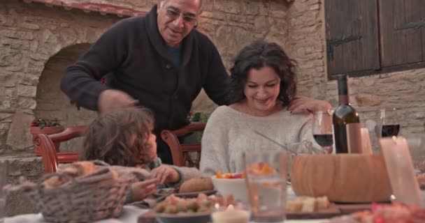 Avô beijando e abraçando avó e neto na mesa de jantar — Vídeo de Stock