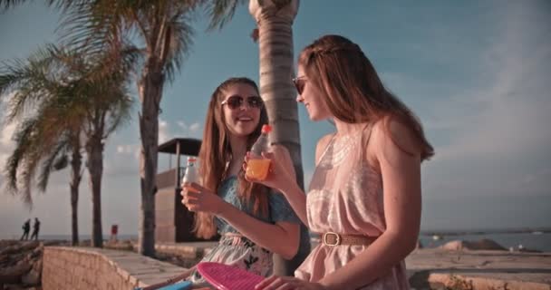Hipster adolescentes con patinetas y refrescos relajarse en la playa — Vídeos de Stock