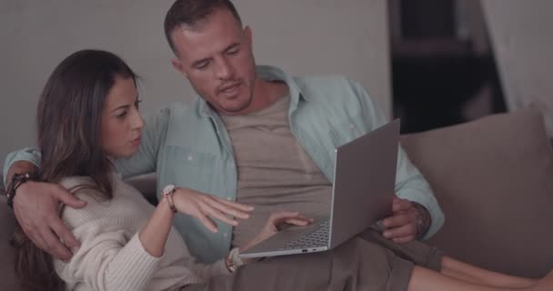 Elegante pareja que trabaja en línea en el hogar utilizando el ordenador portátil — Vídeo de stock