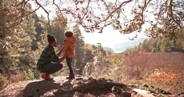 Padre e hijo de pie en la montaña y mirando a la vista — Vídeo de stock