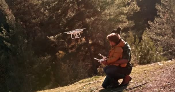 Hipster padre y joven hijo volando drone juntos en la naturaleza — Vídeo de stock