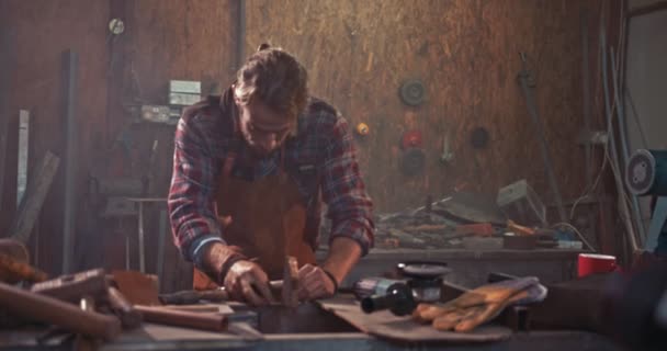 Kovář pracující s kladivem a hřebíky v průmyslové dílně — Stock video