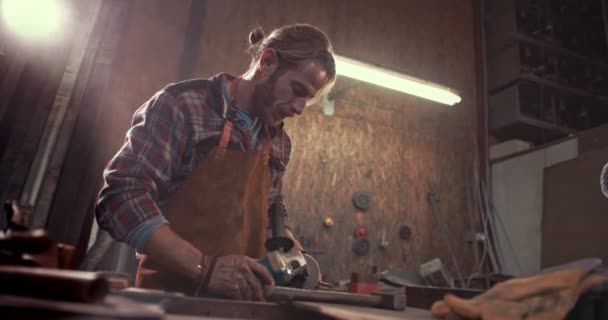 Herrero usando herramientas eléctricas y trabajando en metal en taller — Vídeo de stock
