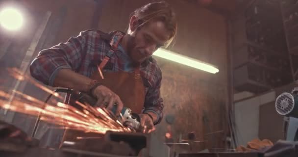 Artesano trabajando con metal en fábrica usando amoladora angular — Vídeo de stock