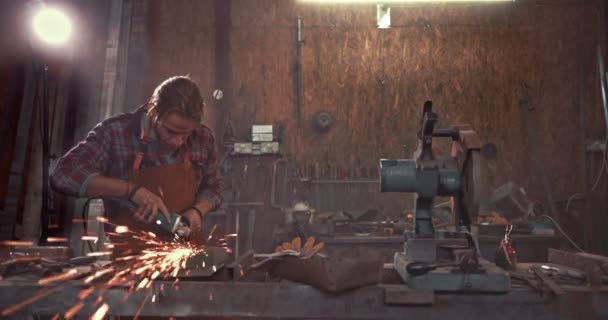Herrero trabajando con amoladora angular en banco de trabajo en garaje industrial — Vídeo de stock