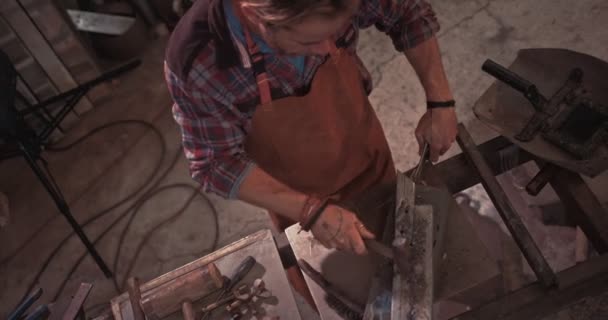 Forgeron utilisant le marteau et travaillant sur le métal soudé en atelier — Video