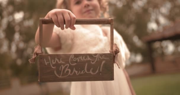 Милая цветочница держит корзину цветов на деревенской свадьбе на открытом воздухе — стоковое видео
