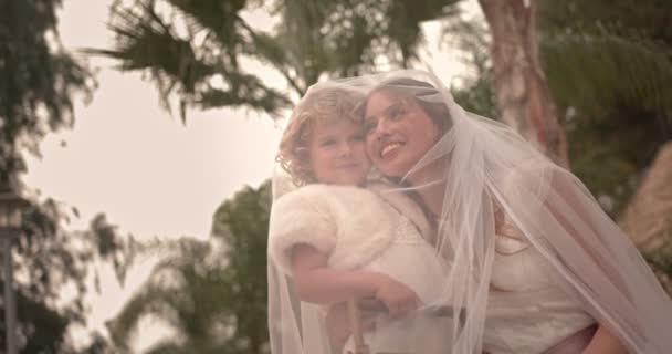 Elegant bride hugging cute flower girl on wedding day — Stock Video