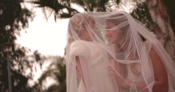 Прихильна наречена обіймає квітку дівчину під весільною сукнею — стокове відео