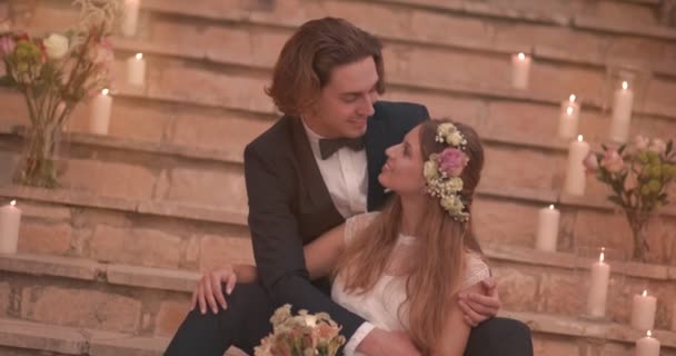 Новоспечений наречений і наречений розслабляються сидячи на кам'яних сходах — стокове відео