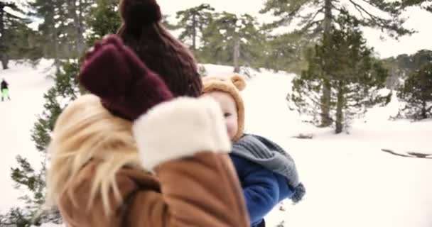 Νεαρή μητέρα διασκεδάζει με την κορούλα της στο χιονισμένο δάσος — Αρχείο Βίντεο