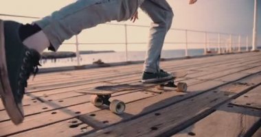 Şehirli iskelede uzun sörf yapan genç hippi.