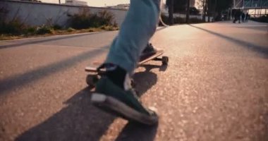 Şehirde kaykay yapan hippi adamın yakın çekimi.