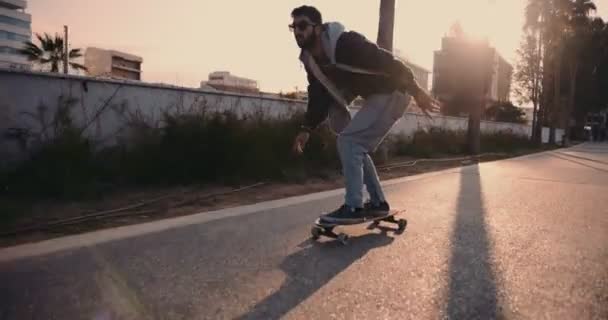 Jonge hipster skateboarder doet longboarden in urban street — Stockvideo