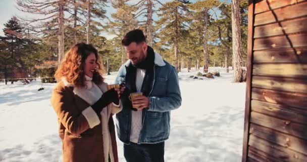 Pareja joven bebiendo chocolate caliente en estación de esquí de invierno — Vídeo de stock