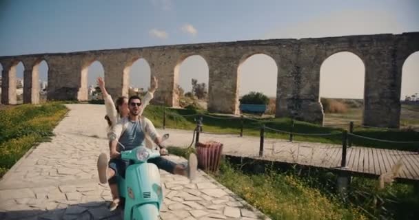 Tourist friends having fun riding retro scooter in European city — Stock Video
