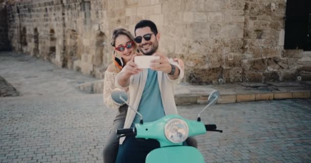 Jóvenes turistas pareja con scooter retro tomando selfies en verano — Vídeo de stock