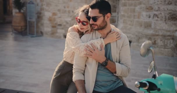 Turistas casal sentado em scooter e abraçando na cidade velha — Vídeo de Stock