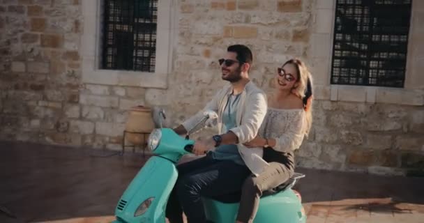 Jovens turistas casal montando scooter vintage em férias na Europa — Vídeo de Stock