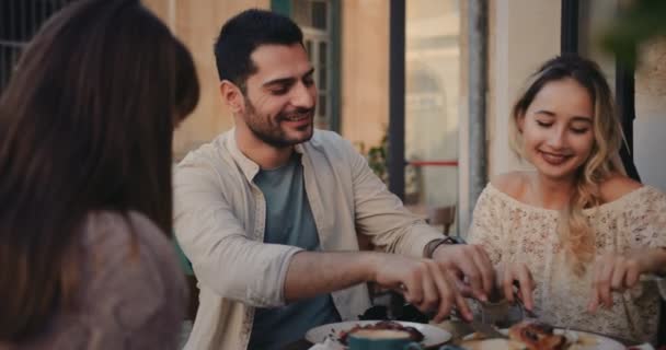 Молодая пара веселится с друзьями в традиционном кафе — стоковое видео