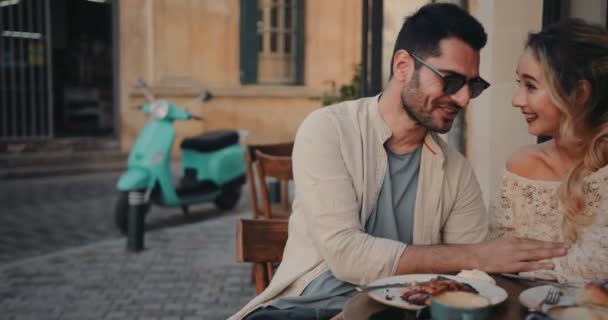 若い観光客はイタリアのコーヒーショップで朝食を持っているカップル — ストック動画