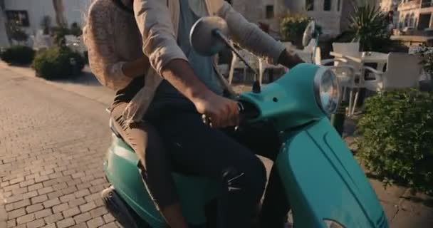 Young couple riding retro motorcycle on cobblestone European city street — 비디오