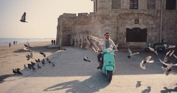 Jovens turistas casal montando scooter na antiga cidade europeia — Vídeo de Stock