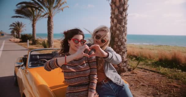 Wanita dengan mobil retro convertible membuat bentuk hati dengan tangan — Stok Video