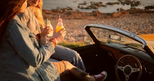 Hipster mulheres em retro conversível carro beber refrigerante na praia — Vídeo de Stock