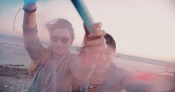 Unga hipster kvinnor firar med färgglada rökbomber på stranden — Stockvideo