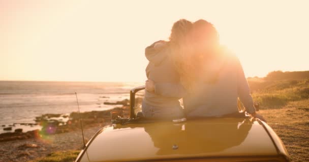 Jonge vrouwen met converteerbare auto ontspannen aan het strand bij zonsondergang — Stockvideo