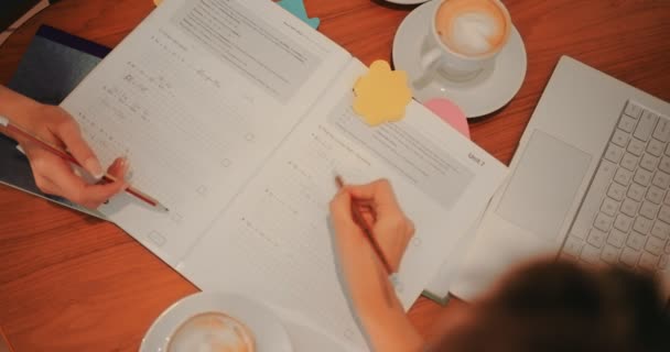 Vista superior de estudiantes universitarios resolviendo ejercicios de matemáticas en la cafetería — Vídeo de stock