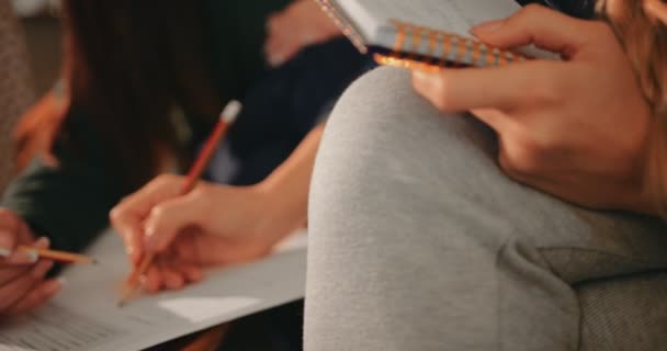Primer plano de las jóvenes estudiantes que escriben en cuaderno en la cafetería — Vídeo de stock