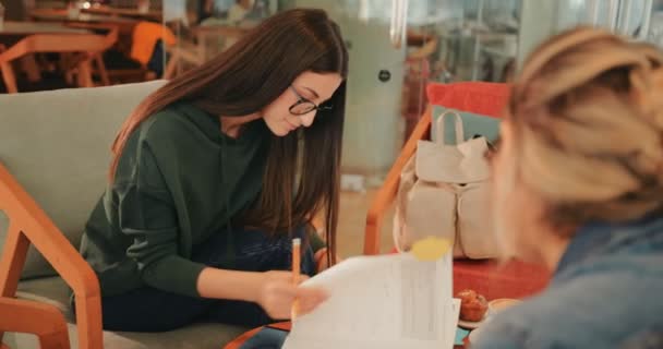 Amigos estudando juntos para a universidade e beber café no café — Vídeo de Stock