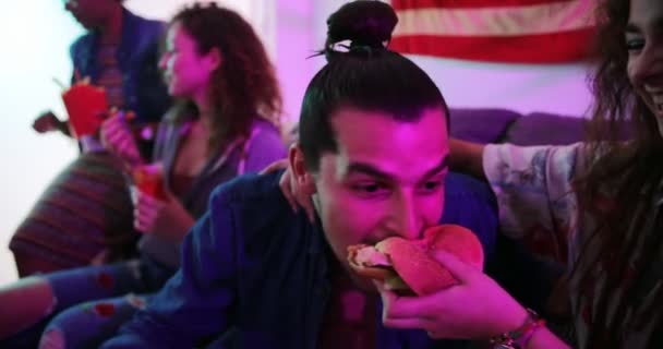 Подростки весело едят гамбургеры из фаст-фуда дома — стоковое видео