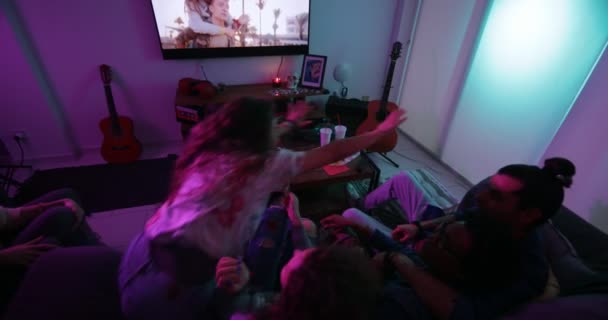 Многоэтнические друзья-подростки развлекаются, смотря телевизор дома — стоковое видео