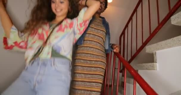 Heureux amis adolescents marchant dans l'escalier du bâtiment et riant ensemble 