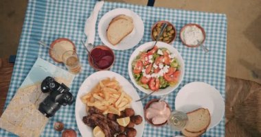 Köy restoranında geleneksel Yunan yemekleri bulunan turistler masası