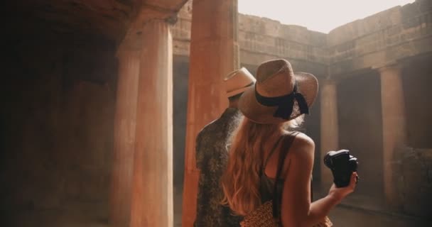 Pareja de turistas jóvenes en Grecia tomando fotos de columnas antiguas — Vídeo de stock