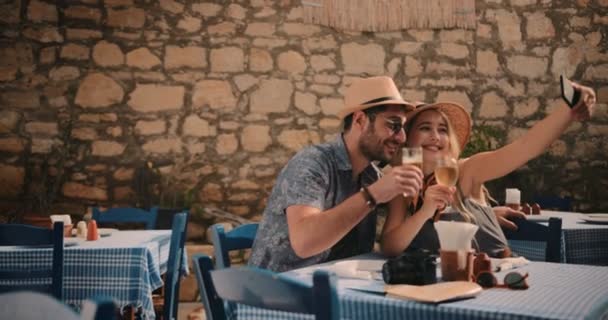 Jovens turistas casal tirando selfies no tradicional restaurante mediterrânico — Vídeo de Stock