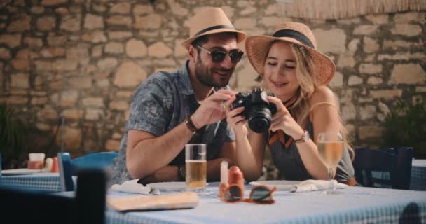 Turister tittar på bilder på kameran på traditionell grekisk restaurang — Stockvideo