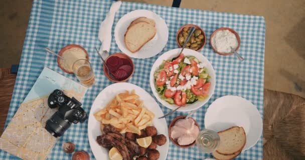 Mesa de turistas con comida griega tradicional en restaurante rústico — Vídeos de Stock