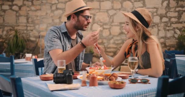 Młodzi turyści jedzą lunch w tradycyjnej greckiej tawernie — Wideo stockowe