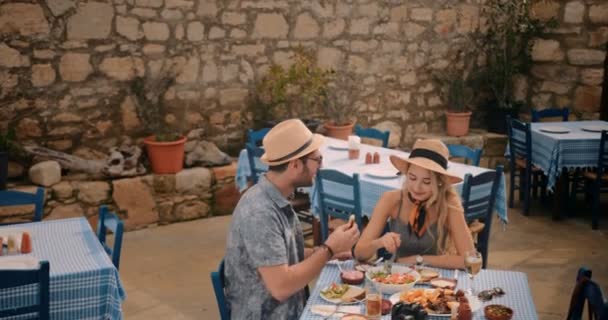 Unga turister par har roligt att äta på grekiska taverna — Stockvideo